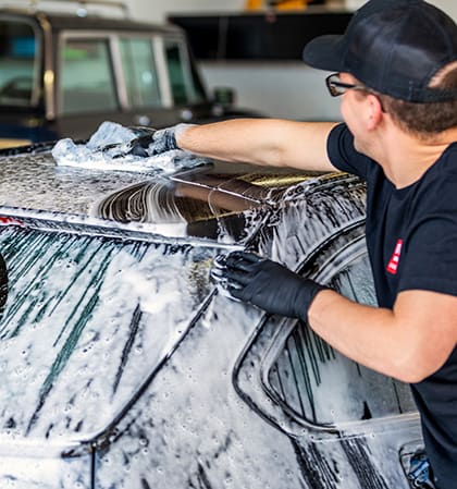 Washing roof of car with wash mitt