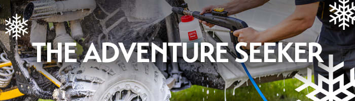 Person rinsing mud off an off-road vehicle with a pressure washer and the words 'The Adventure Seeker' — rugged car care gifts for outdoor enthusiasts from Griot's Garage.